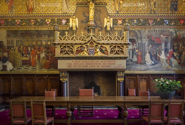 Interior of Bruges' city hall showing the Gothic hall with monumental mantelpiece and 19th century murals