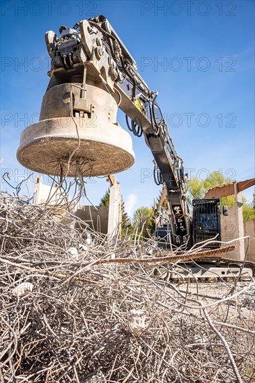 Black Liebherr crawler excavator with magnet recycling on demolition site