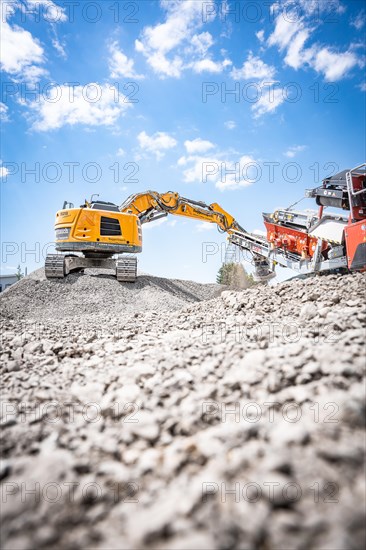 Yellow Liebherr crawler excavator recycling on demolition site