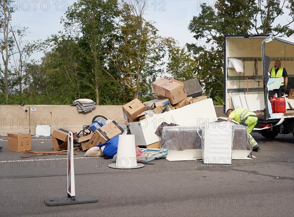 Rescue workers collect the load of a small truck from the carriageway of the A48 motorway in the area of the Koblenz interchange after the collision of the truck with an articulated lorry. Koblenz