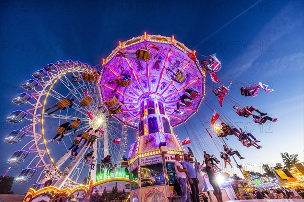 Ferris wheel and historic chain carousel in the evening