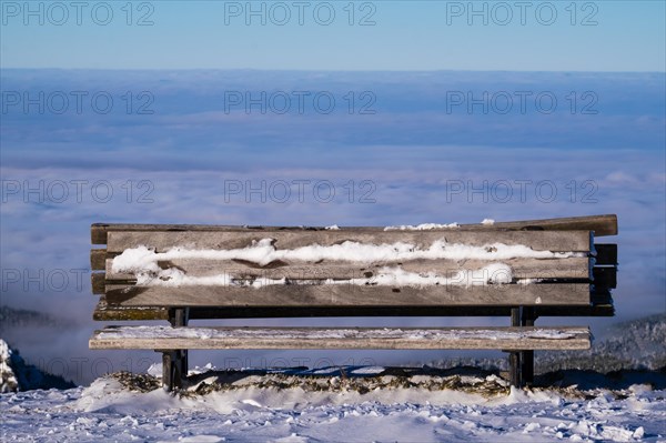 A frozen lookout bench with a view of the sea of fog at Brauneck in Lenggries