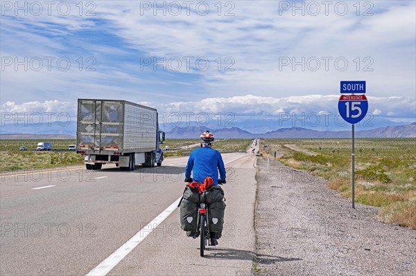Solitary touring cyclist cycling along the Interstate 15