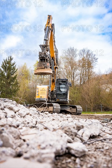 Yellow Liebherr crawler excavator with magnet recycling on demolition site