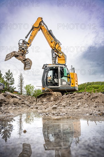 Yellow Liebherr crawler excavator recycling on demolition site