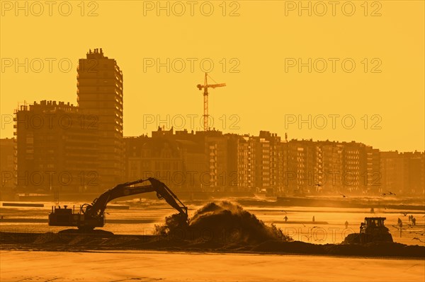 Bulldozer and hydraulic excavator installing pipeline during sand replenishment