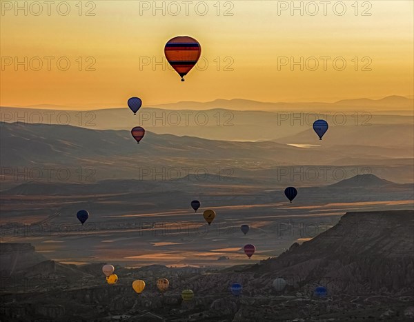 Hot air balloons flying over Cappadocia at sunrise