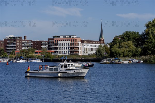 Illegally anchored houseboats in the Rummelsburg Bay with the residential houses on the Rummelsburg shore