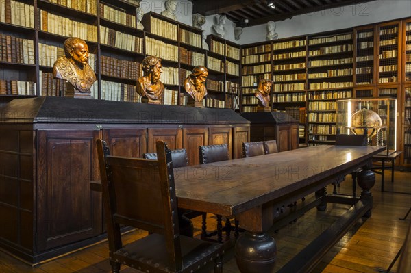 Bookshelves with old books in the 17th century Great Library at the Plantin-Moretus Museum