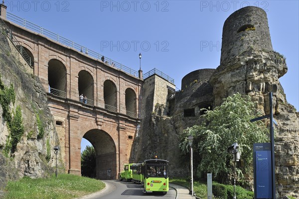 Tourist train Petrusse Express rides under the viaduct Schloss Erbaut Bruecke at Luxembourg