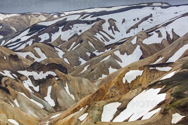 Sulphur coloured rhyolite mountains with patches of snow at Brennisteinsalda volcano near Landmannalaugar