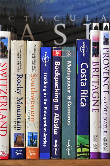 Collection of travel guides about worlwide holiday destinations on a bookshelf