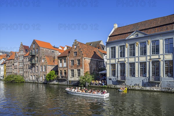 Sightseeing boat with tourists navigating on the river Leie