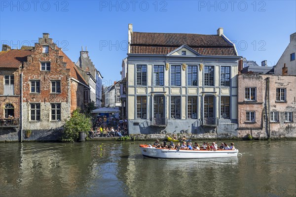 Sightseeing boat with tourists navigating on the river Leie