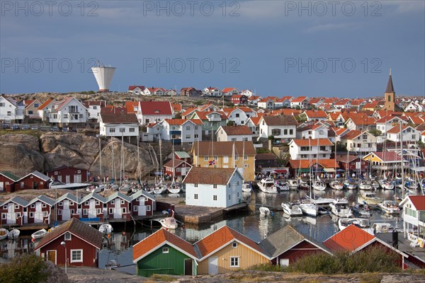 Colourful traditional fishing huts and boathouses along wooden pier at Smoegen