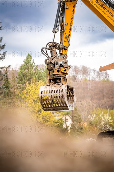 Yellow Liebherr crawler excavator recycling on demolition site