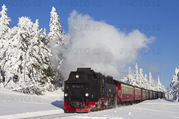 Steam train riding the Brocken Narrow Gauge railway line in the snow in winter at the Harz National park