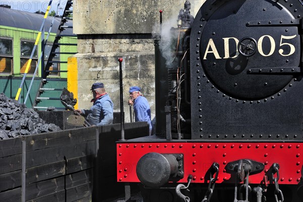 Men loading coal as fuel for steam train at the depot of the Chemin de Fer a Vapeur des Trois Vallees at Mariembourg