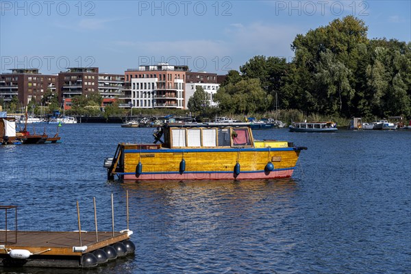 Illegally anchored houseboats in the Rummelsburg Bay with the residential houses on the Rummelsburg shore