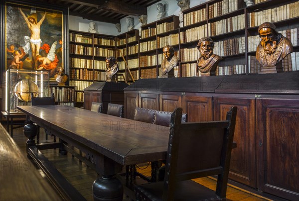 Bookshelves with old books in the 17th century Great Library at the Plantin-Moretus Museum