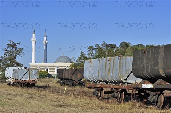 Minarets of the Turkish Islamic Fatih Mosque of immigrant workers and wagons of the coal mine museum at Beringen