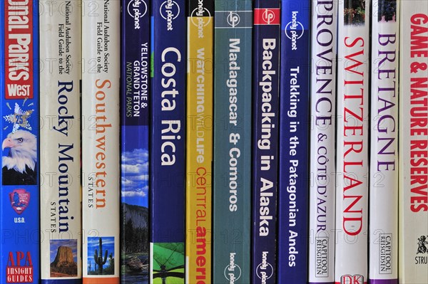 Collection of travel guides about worlwide holiday destinations on a bookshelf