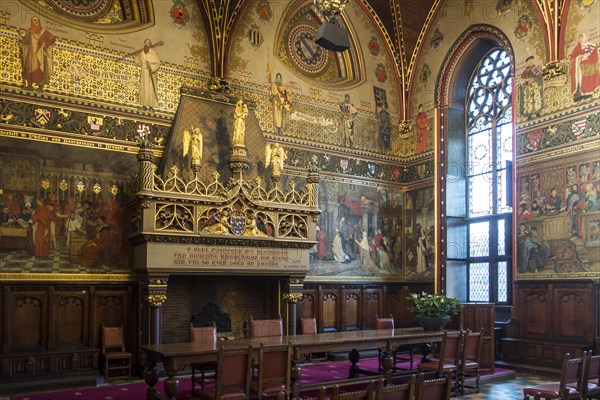 Interior of Bruges' city hall showing the Gothic hall with monumental mantelpiece and 19th century murals
