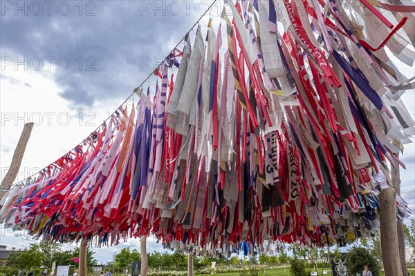 Strips of past cut-up Kirchentag and Katholikentag banners as sun protection at the ecumenical stand of the Protestant and Catholic churches at the Bundesgartenschau