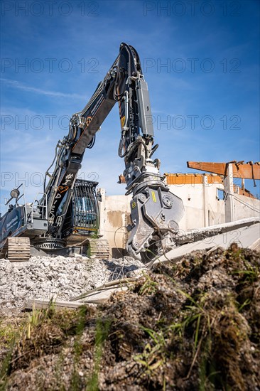 Black Liebherr crawler excavator with spreader recycling on demolition site