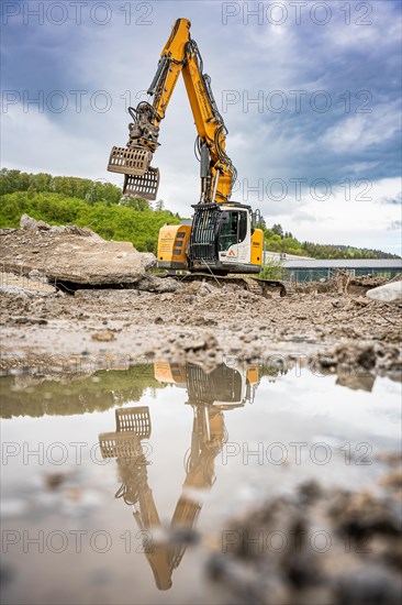 Yellow Liebherr crawler excavator recycling on demolition site