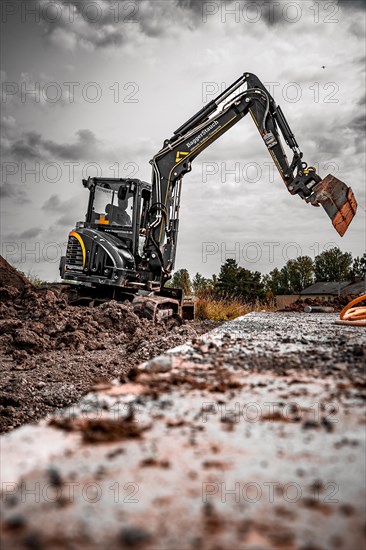 Black Yanmar Mini tracked excavator during earthworks for house construction on building site