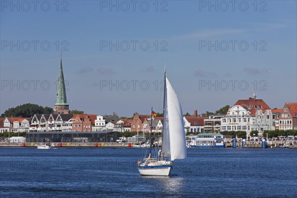 Sailing boat on the river Trave in front of Vorderreihe at Travemuende