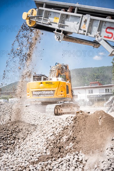 Yellow Liebherr crawler excavator recycling on demolition site