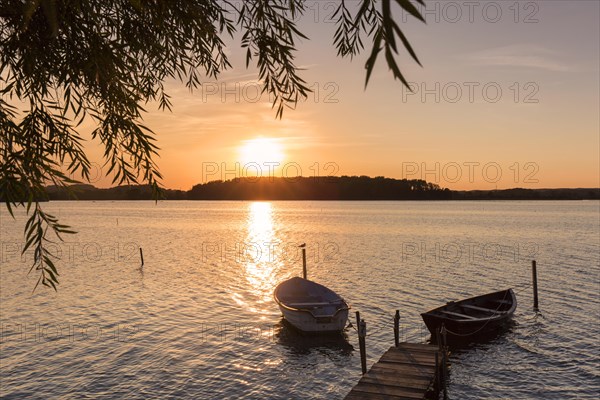 Wooden jetty with boats on Neustaedter Binnenwasser lake at Neustadt in Holstein