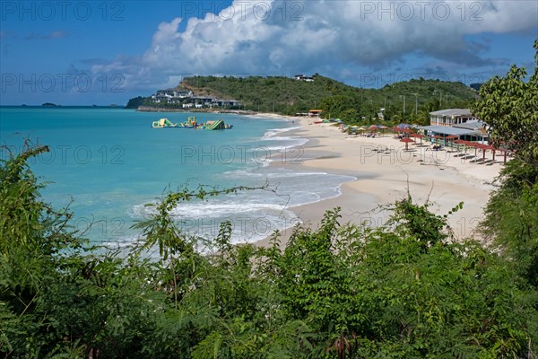 White sandy beach and azure-blue water at seaside resort along along the west coast of the island Antigua