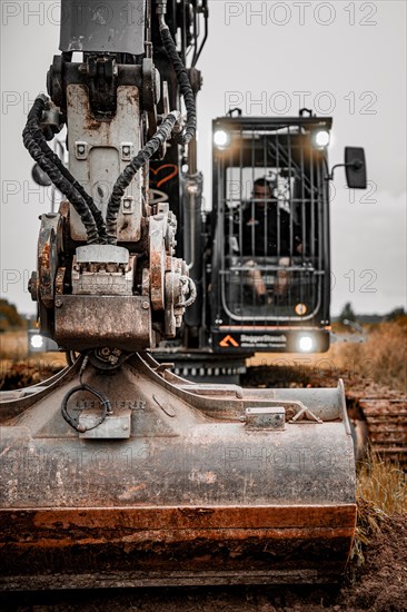 Black Liebherr crawler excavator excavating earth for house construction on building site