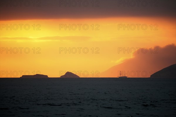 Three-master sailing ship at sunset in front of Santiago Island