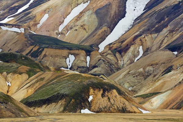 Sulphur coloured rhyolite mountains with patches of snow at Brennisteinsalda volcano near Landmannalaugar
