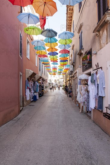 Alley with colourful umbrellas suspended over a street