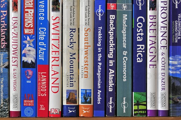 Collection of travel guides about worlwide holiday destinations on a bookshelf