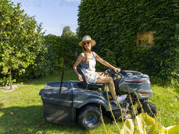 Woman driving lawn mower