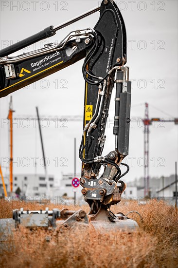 Black Liebherr crawler excavator excavating earth for house construction on building site