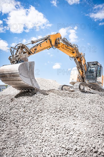 Yellow Liebherr crawler excavator recycling on demolition site