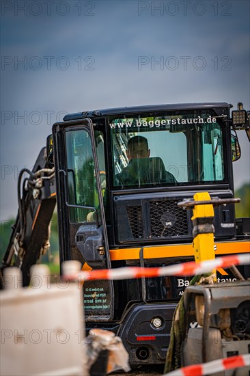 Black Yanmar Mini tracked excavator during earthworks for house construction on building site