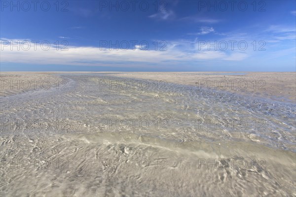 Water flowing through tidal creek into the Wadden Sea along the German North Sea coast