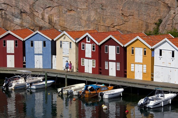 Colourful traditional fishing huts and boathouses along wooden pier at Smoegen