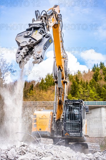 Yellow Liebherr crawler excavator recycling on demolition site