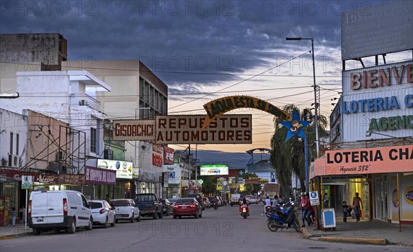 Traffic and shops in the shopping street at sunset in the city Presidencia Roque Saenz Pena