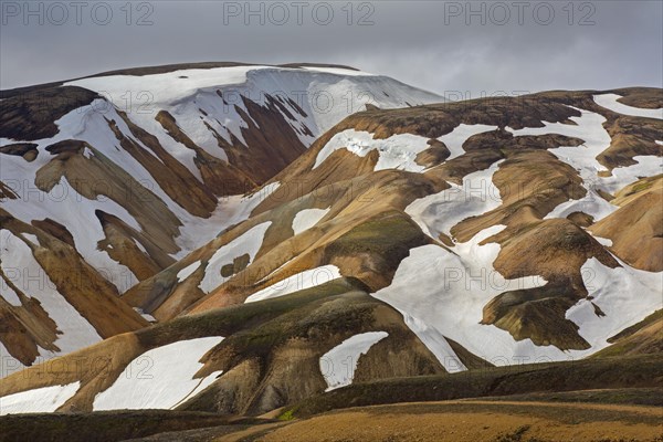 Sulphur coloured rhyolite mountains with patches of snow at Brennisteinsalda volcano near Landmannalaugar