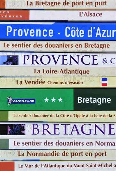 Collection of travel guides about France on a bookshelf